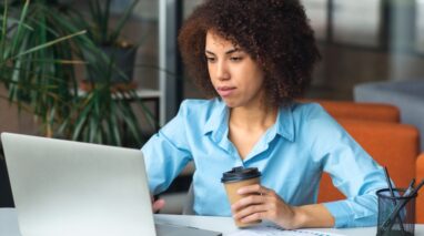 Young African American woman looks at laptop on desk