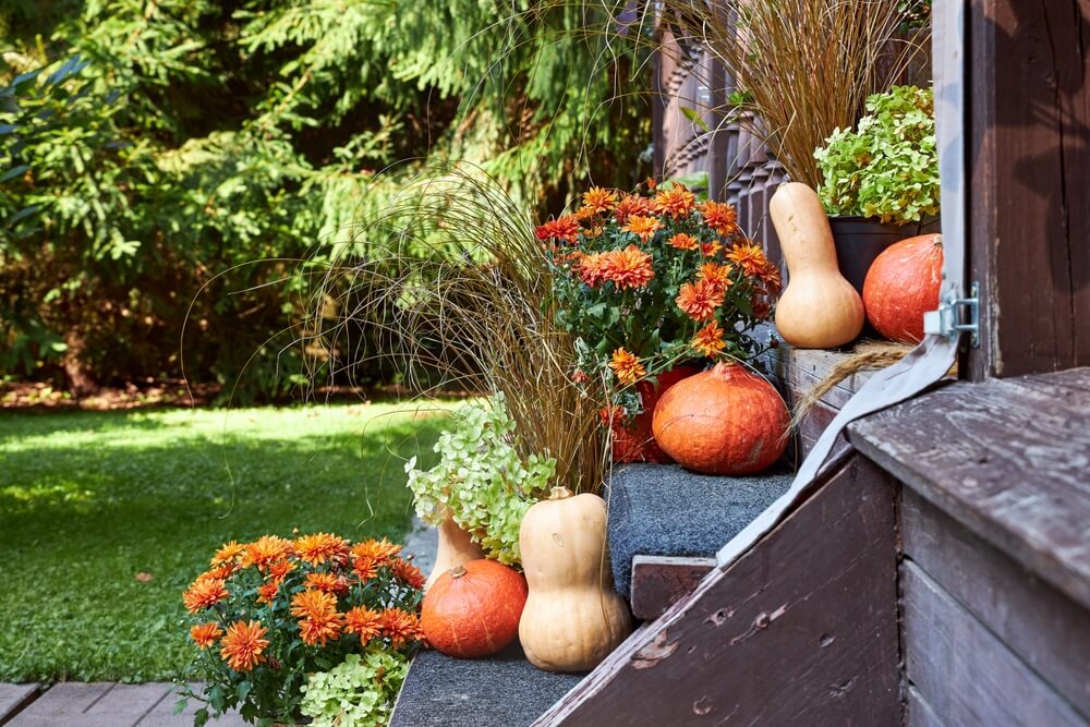 Autumn entryway decor, staircase decor with pumpkins and fall flowers.