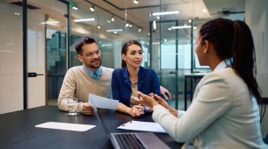 Young couple talking to their independent insurance agent during a meeting in the office.