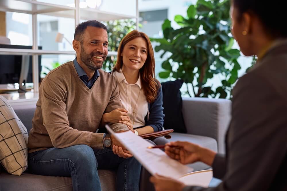 Couple meeting with an advisor at home, highlighting how human expertise matters in a digital insurance world.
