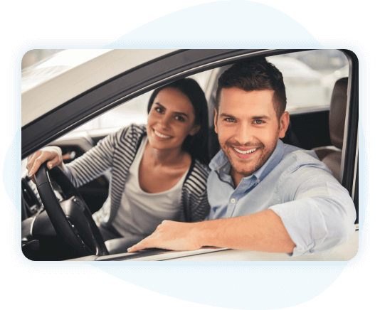 Smiling young couple sitting in parked car